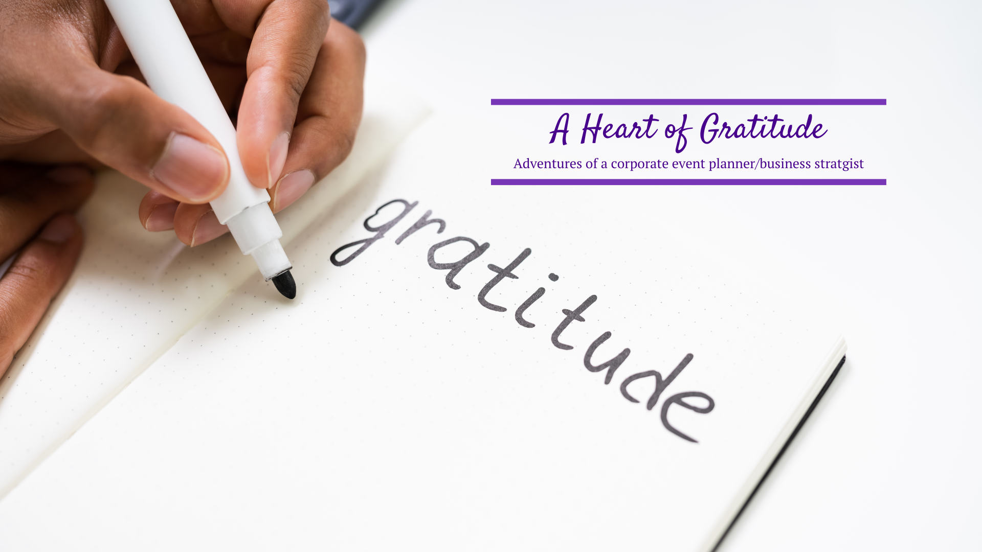 A hand writing the word gratitude in a journal